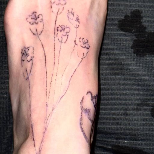 Тату на стопе: нежные полевые цветы